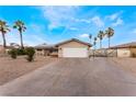 Well-maintained single-story home with a spacious driveway, mature trees, and a two car garage at 1462 Rawhide St, Las Vegas, NV 89119