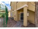 Exterior view of the tan-colored condo featuring desert landscaping and a fenced walkway at 1560 Jamielinn Ln # 101, Las Vegas, NV 89110