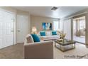 Cozy staged living room with modern decor, a sliding glass door, and neutral tones at 1560 Jamielinn Ln # 101, Las Vegas, NV 89110