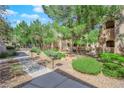 Well-kept landscaping with mature trees and manicured bushes along a walkway at 1909 Mountain Hills Ct # 103, Las Vegas, NV 89128