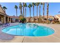 Community pool surrounded by tall palm trees and beautiful landscaping at 2300 E Silverado Ranch Blvd # 1037, Las Vegas, NV 89183