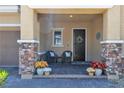 Inviting front porch with decorative columns and chairs that makes the house feel like a home at 2833 Athena Hill Ct, Henderson, NV 89052