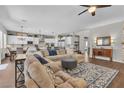 Open-concept living room with hardwood floors and a large sectional couch, adjacent to the kitchen at 2833 Athena Hill Ct, Henderson, NV 89052