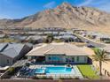 Stunning backyard with a refreshing pool, putting green, covered patio, and mountain views at 3120 Greenscape Ln, Las Vegas, NV 89138