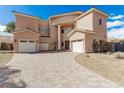 Elegant two-story home featuring a brick driveway, three-car garage, and a desert front yard at 3789 Gershon Ct, Las Vegas, NV 89121