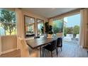 Bright dining area with modern wood table, contemporary mirrors, and access to the outdoor patio at 4181 Nopal Serrano Ave, Las Vegas, NV 89141