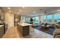 Open-concept living space with modern finishes, large windows, and a stylish kitchen island at 4181 Nopal Serrano Ave, Las Vegas, NV 89141