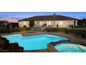 Backyard featuring a large pool and spa, set in a well-maintained yard, ideal for outdoor relaxation and entertaining at 671 W Hickory St, Pahrump, NV 89048