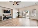 Bright living room with a modern fireplace, sleek entertainment center, and sliding glass doors at 830 Beartooth Falls Ct, Henderson, NV 89052