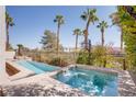 Relaxing backyard pool and spa surrounded by tropical palm trees and landscaping at 12 Cascade Lake St, Las Vegas, NV 89148
