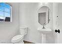 Clean half-bath with pedestal sink and toilet and natural lighting at 1203 Sweet Orange St, Las Vegas, NV 89142