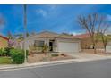 Charming single-story home featuring a two-car garage and desert landscaping at 1404 Dragon Rock Dr, Henderson, NV 89052