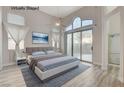 Light-filled bedroom with a large window, ceiling fan, and access to an en-suite bathroom at 1700 Wandering Winds Way, Las Vegas, NV 89128