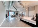 Spacious living area with industrial-chic exposed ductwork, a modern kitchen, and expansive city views through large windows at 200 Hoover Ave # 1210, Las Vegas, NV 89101