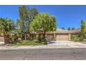 Well-maintained single-Gathering home with a lush green lawn, mature trees, and a two-car garage at 2020 Sinfonia Ave, Henderson, NV 89052