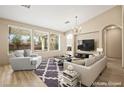 Bright living room featuring large windows, wood floors, modern furnishings, and a cozy fireplace at 2295 Aria Dr, Henderson, NV 89052
