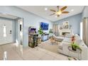 Bright living room with light blue walls, tile flooring, fireplace, ceiling fan, and contemporary furnishings at 3610 El Camino Rd, Las Vegas, NV 89103