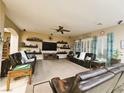 Spacious living room featuring plush seating, a ceiling fan, and floating shelves for decor at 4242 Helena Hideaway Ct, Las Vegas, NV 89129