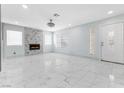 Expansive living room featuring marble floors, a fireplace, and multiple windows for abundant natural light at 5516 Cory Pl, Las Vegas, NV 89107