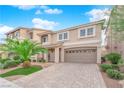 Two-story home featuring desert landscaping, tile roof, two-car garage, and front porch seating area at 6435 Parrot Ridge Ct, Las Vegas, NV 89139