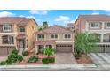 An elevated view of a two-story home with a landscaped front yard and brick driveway at 6435 Parrot Ridge Ct, Las Vegas, NV 89139