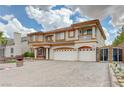 Beautiful two-story home with three-car garage, a charming front garden and decorative gate at 6491 Bright Nimbus Ave, Las Vegas, NV 89139