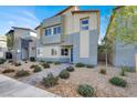 Modern two-story home with a neutral color scheme, rock landscaping, and a paved walkway at 7476 Moonglade St, North Las Vegas, NV 89084