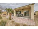 A covered patio with outdoor furniture and a brick walkway, perfect for relaxation and entertaining at 7567 Wingspread St, North Las Vegas, NV 89084
