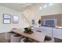 Open-concept living room and dining area with stylish furniture and a tall, vaulted ceiling at 800 Fetter Ct, Henderson, NV 89052