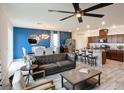 Bright, open living space featuring modern furnishings, a ceiling fan, dining area, and stylish kitchen with island at 8432 Alder Rain St, Las Vegas, NV 89113