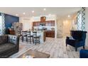 Open-concept living area with a spacious layout, featuring wood-look floors, and modern furnishings at 8432 Alder Rain St, Las Vegas, NV 89113