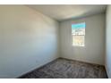 A bright bedroom featuring neutral carpet, walls, and a window with natural light at 9067 Mapledale Ranch Ct, Las Vegas, NV 89139