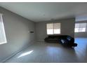 Spacious living room with tile flooring, multiple windows providing natural light, and a black leather sofa at , Las Vegas, NV 89148