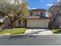 Inviting home featuring a two-car garage and a well-maintained front lawn with mature tree at 141 Fox Lake Ave, Las Vegas, NV 89148
