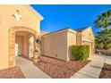 Side view of home featuring desert landscaping, brick archway, and beige exterior paint at 2186 Savannah River St, Henderson, NV 89044