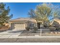 Charming single-story home featuring a two-car garage, xeriscaping, and mature trees at 2384 Yellow Bird Ct, North Las Vegas, NV 89084