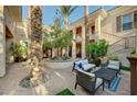 Inviting courtyard features seating area, tall palm trees, and architectural columns at 3863 Glasgow Green Dr, Las Vegas, NV 89141