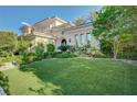 An elegantly stucco home with a beautifully maintained front lawn and manicured shrubs at 3863 Glasgow Green Dr, Las Vegas, NV 89141