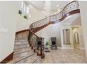 Grand foyer with a curved staircase and elegant chandelier at 3863 Glasgow Green Dr, Las Vegas, NV 89141