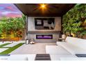 Outdoor living space with a fireplace, mounted TV, and comfortable lounge seating at 3929 Reyes Ave, Las Vegas, NV 89141