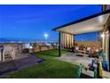 An inviting backyard with artificial turf, a covered patio, and city views at 5236 Sunstone Mesa Dr, Las Vegas, NV 89166