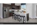 Modern kitchen with stainless steel appliances, dark wood cabinets and an island with seating at 5757 Crenellated St # Lot 61, Las Vegas, NV 89148
