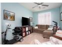 Cozy living room with plush seating, a ceiling fan, and natural light streaming through plantation shutters at 609 Viale Machiavelli Ln, Henderson, NV 89011