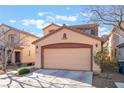 Two-story home with neutral exterior featuring a two-car garage and simple landscaping at 6697 Boom Town Dr, Las Vegas, NV 89122