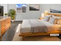 Light and airy bedroom featuring a wood frame bed, dresser, and minimalist decor at 7110 Brighton Village St, Las Vegas, NV 89166