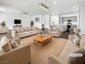 Spacious living room features contemporary furnishings, a ceiling fan, and an open-concept kitchen view at 7110 Brighton Village St, Las Vegas, NV 89166