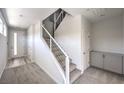 Bright foyer with carpeted stairs and metal handrails, featuring gray built-in cabinetry and a white front door at 8629 Ensworth St # 111, Las Vegas, NV 89123