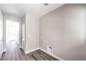 Hallway with wood-look floors, white doors, and a utility hookup; bright and clean at 8629 Ensworth St # 111, Las Vegas, NV 89123