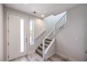 Bright entryway features a modern staircase with metal railings and stylish, light wood flooring at 8629 Ensworth St # 112, Las Vegas, NV 89123