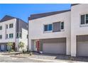 Contemporary two-story home featuring neutral colors and a two-car garage, set against a blue sky at 8629 Ensworth St # 112, Las Vegas, NV 89123